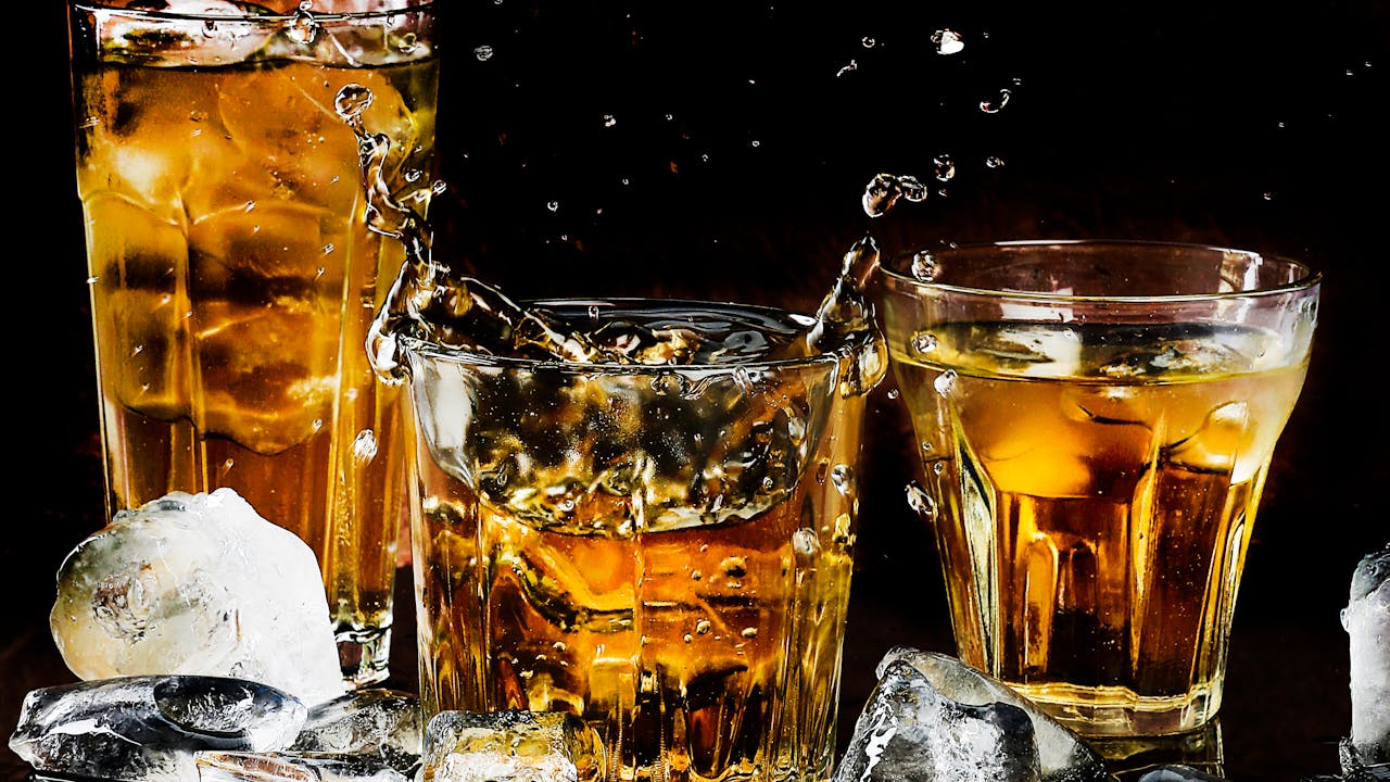 Whiskey glasses and accessories on a dark surface