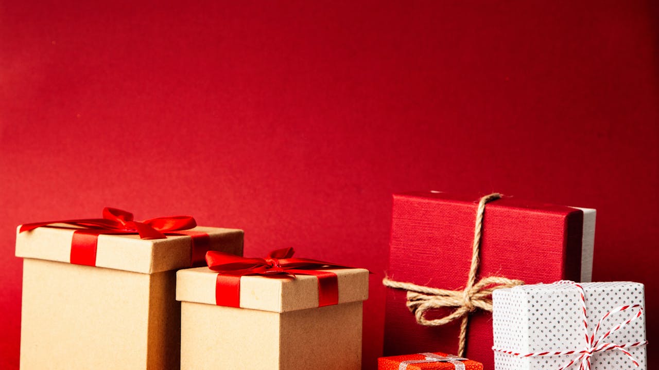 Beautifully wrapped gift boxes with red ribbons and rose petals