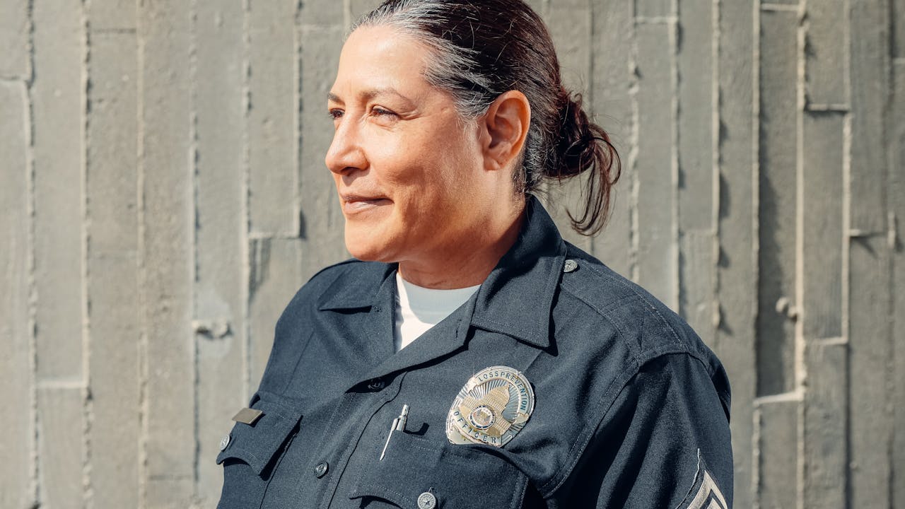 Female police officer in uniform with badge, looking thoughtfully to the side